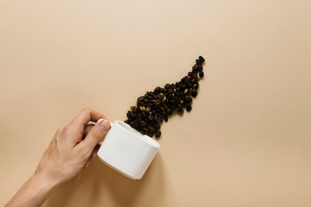 hand-holding-white-cup-with-coffee-beans_23-2148267879.jpg